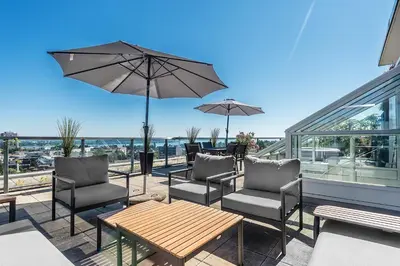 a patio with chairs and a table with an umbrella at SOHO PENTHOUSE !Gratis Parken, Free Parking! in Kreuzlingen