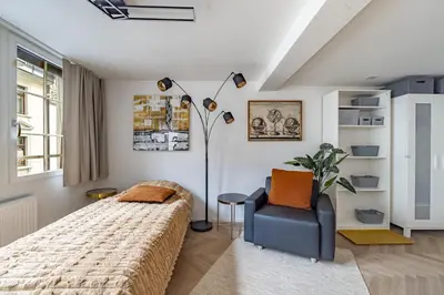 a bedroom with a bed and a chair at Ferien Studio Wohnung Altstadt Multergasse 20 in St. Gallen