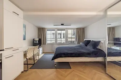 a bedroom with a bed and a desk with chairs at Ferien Studio Wohnung Altstadt Multergasse 20 in St. Gallen