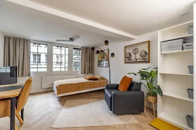 a bedroom with a bed and a desk and a table at Ferien Studio Wohnung Altstadt Multergasse 20 in St. Gallen