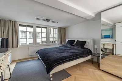 a bedroom with a large bed in a room with windows at Ferien Studio Wohnung Altstadt Multergasse 20 in St. Gallen