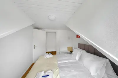 a attic room with a bed with white pillows at book2stay moderne Wohnung OLMA-Areal in St. Gallen