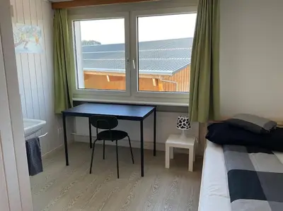a bedroom with a desk and a window and a bed at 11 - Gästehaus Erika - Hundwil - Appenzellerland in Hundwil