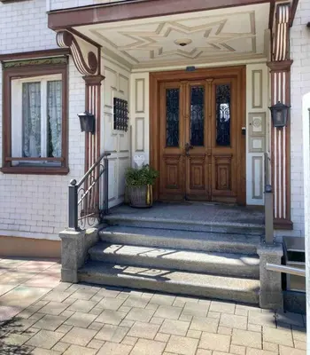 a house with a wooden door and stairs in front at 11 - Gästehaus Erika - Hundwil - Appenzellerland in Hundwil