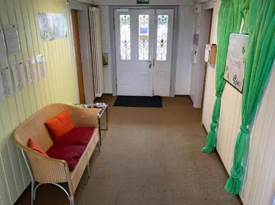 a hallway with a couch and a table and a door at 07 - Gästehaus Erika - Hundwil - Appenzellerland in Hundwil