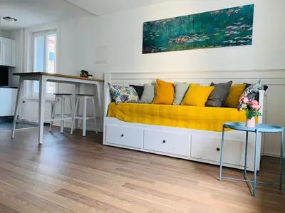 a couch with yellow pillows and a table in a room at Klein aber Fein in Rorschach in Rorschach