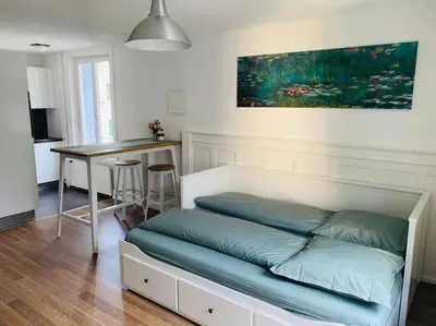 a bed in a living room with a table at Klein aber Fein in Rorschach in Rorschach