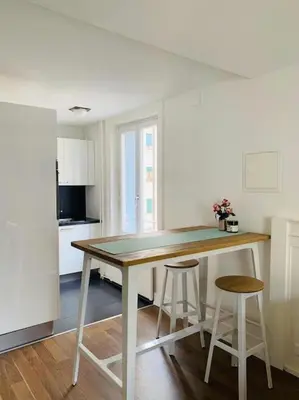 a kitchen with a wooden table and two stools at Klein aber Fein in Rorschach in Rorschach