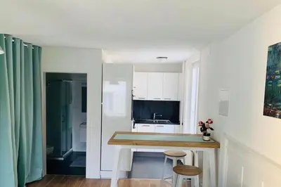 a kitchen with a table and two stools in a room at Klein aber Fein in Rorschach in Rorschach