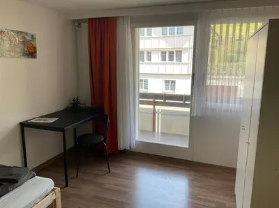 a room with a desk and a window with a table at 12 - Gästehaus Erika - Hundwil - Appenzellerland in Hundwil