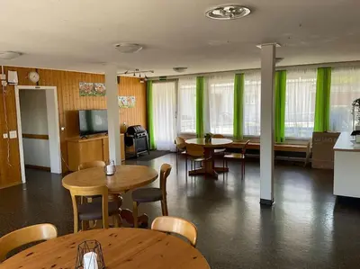 a room with tables and chairs and green curtains at 12 - Gästehaus Erika - Hundwil - Appenzellerland in Hundwil