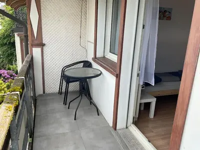 a small table and chair on the porch of a house at 24 - Gästehaus Erika - Hundwil - Appenzellerland in Hundwil