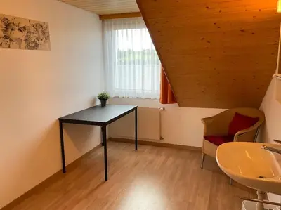 a room with a table and a chair and a window at 27 - Gästehaus Erika - Hundwil - Appenzellerland in Hundwil