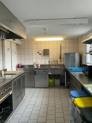 a large kitchen with stainless steel counters and appliances at 28 - Gästehaus Erika - Hundwil - Appenzellerland in Hundwil
