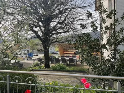 a tree with tables and chairs next to a street at 28 - Gästehaus Erika - Hundwil - Appenzellerland in Hundwil