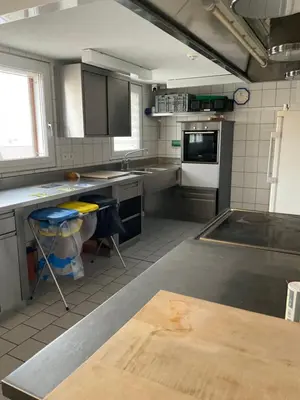 a kitchen with stainless steel counter tops and appliances at 28 - Gästehaus Erika - Hundwil - Appenzellerland in Hundwil