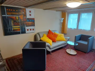 a living room with a couch and a chair at Bauernhaus Hinterbühle in Wolfhalden
