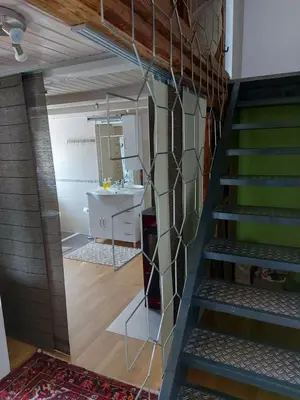 a staircase leading to a bathroom with a sink at Bauernhaus Hinterbühle in Wolfhalden