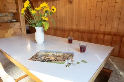 a table with two glasses and a vase with flowers at Dorea in Wildhaus