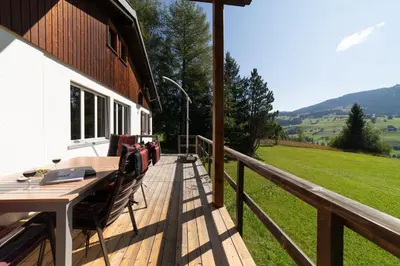 a wooden deck with a table and chairs on a house at Dorea in Wildhaus