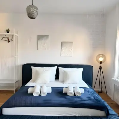 a bed with white pillows and a blue blanket at Apartment im Zentrum St Gallen in St. Gallen