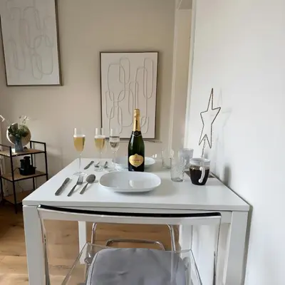 a white table with a bottle of wine and glasses at Apartment im Zentrum St Gallen in St. Gallen