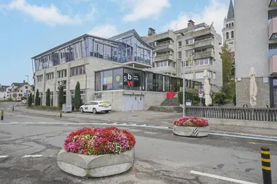 a city street with two large buildings and flowers at book2stay - Lakeview Apartment in Romanshorn
