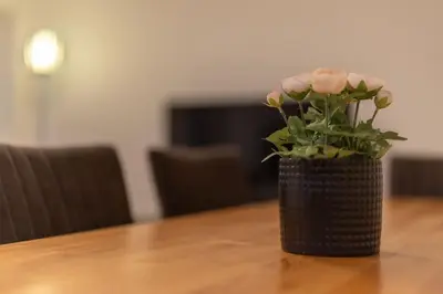 a vase with pink flowers sitting on a table at Jasminkas Host 2, Ruhig, City und Naturnah, Gratis Parkplatz und Balkon in St. Gallen