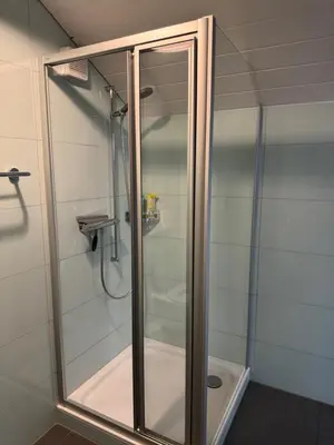 a shower with a glass door in a bathroom at Altstadt Gästehaus in Arbon