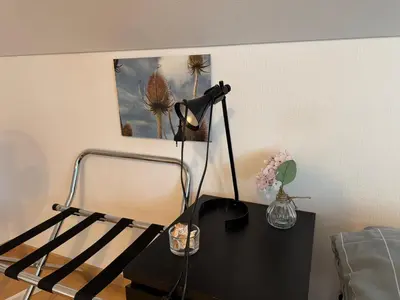 a black table with a lamp and a picture on the wall at Altstadt Gästehaus in Arbon