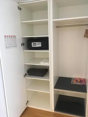 a closet with white shelves and a microwave at Hotel Flawil in Flawil