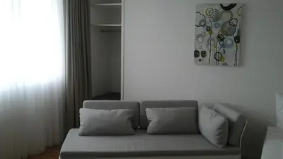 a couch in a living room with a painting on the wall at Hotel Flawil in Flawil