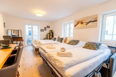 two beds in a room with a table and chairs at Jasminkas Host 1, Ruhig, Gratis Parkplatz Balkon & im 1, Stockwerk in St. Gallen
