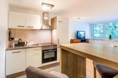 a kitchen with white cabinets and a wooden counter top at Nachhaltig Wohnen im 1, Stock, gratis Parkplatz! in St. Gallen