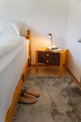 a bedroom with a sink and a bed with two chairs at Fuechsle in Wildhaus