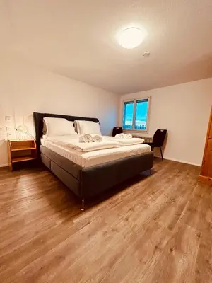 a bedroom with a bed and a wooden floor at Private room with Bathroom and Lake View in Guest House in Heiden