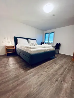 a bedroom with a bed and a wooden floor at Private room with Bathroom and Lake View in Guest House in Heiden
