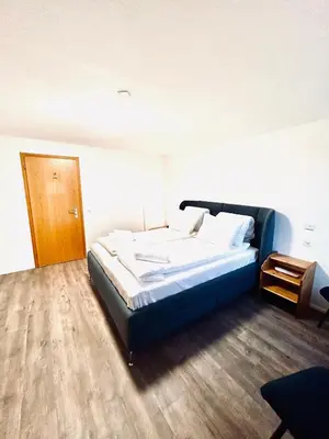 a bedroom with a bed and a wooden floor at Private room with Bathroom and Lake View in Guest House in Heiden