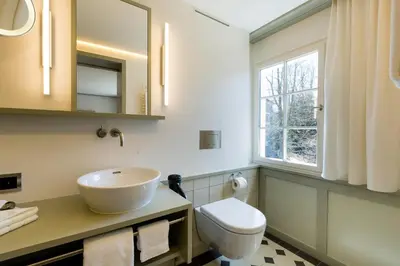 a bathroom with a sink and a toilet and a window at Hotel Krone Speicher in Speicher
