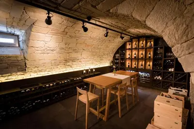 a wine cellar with a wooden table and chairs at Hotel Krone Speicher in Speicher