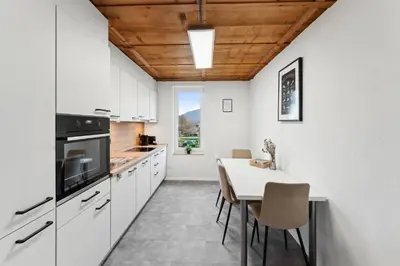 a kitchen with white cabinets and a table with chairs at FENUS SGT10 Panoramaview Parking Kitchen in Grabs