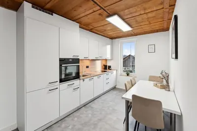a kitchen with white cabinets and a table with chairs at FENUS SGT10 Panoramaview Parking Kitchen in Grabs