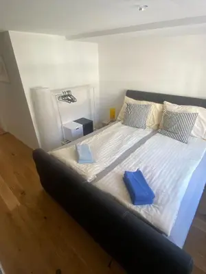 a large bed with two blue pillows on it at Zentrales Schloss Apartment in Arbon