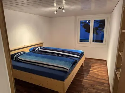 a bedroom with a bed in a room with a window at Heimelige Wohnung auf der Schwägalp in Urnäsch