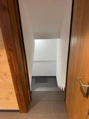 an open door to a hallway with a stair case at Heimelige Wohnung auf der Schwägalp in Urnäsch