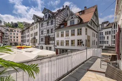 a kitchen with white cabinets and a table and chairs at Ferienwohnungen Webergasse 23 in St. Gallen