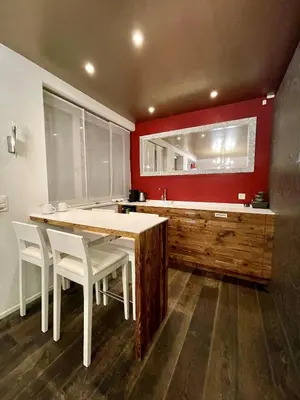 a kitchen with a wooden table and white chairs at Private SPA Seeliebe - Ihre Ruheoase in Amriswil