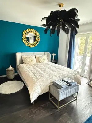 a bedroom with a large bed and a blue wall at Suite Executive Kreuzlingen - MTL Schweiz in Kreuzlingen
