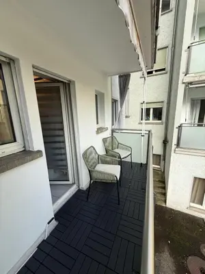 a balcony with two chairs and a window at Suite Executive Kreuzlingen - MTL Schweiz in Kreuzlingen