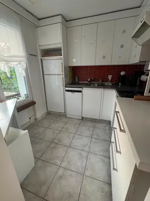 a kitchen with white cabinets and a tile floor at 3 Zimmer-Ferienwohnung in der Rüti in Herisau